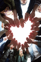 group of teens making a heart with their hands 