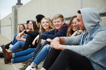 group of teens sitting on a parking deck 