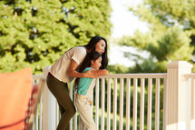 a woman standing on a back porch and daughter 