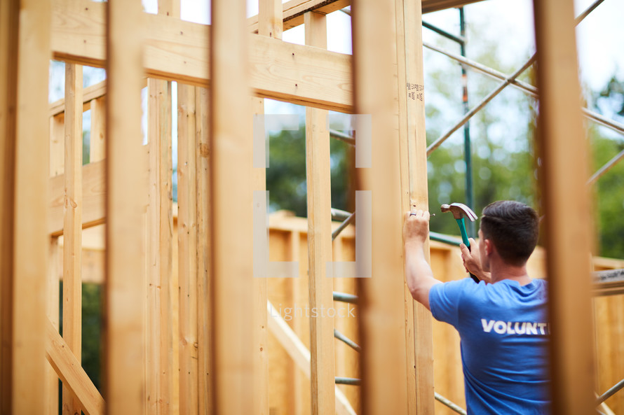 a volunteer building a house 