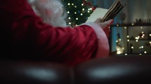 Santa Claus reading an old book on the sofa 