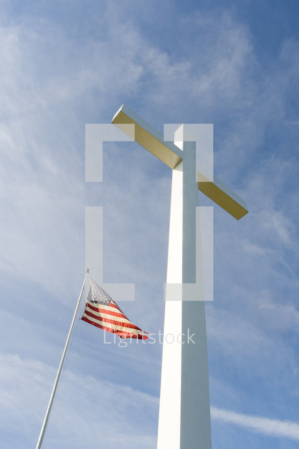 a tall white cross and an American flag