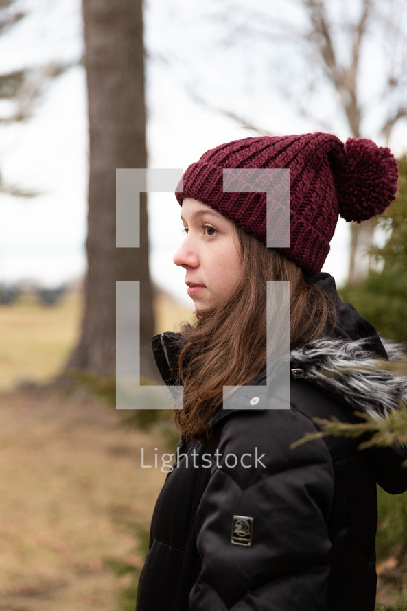 a teen girl standing outdoors in winter 