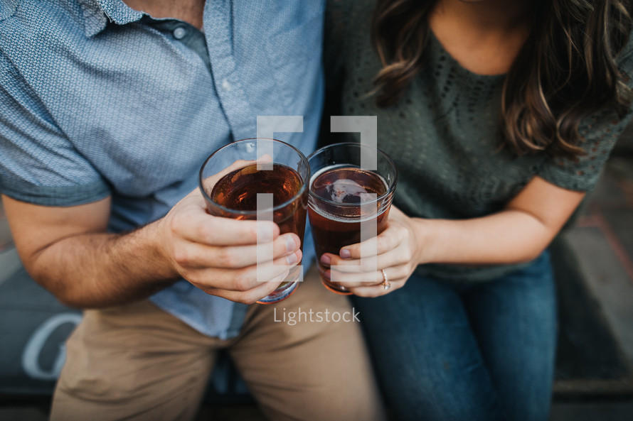 couple holding beer glasses 