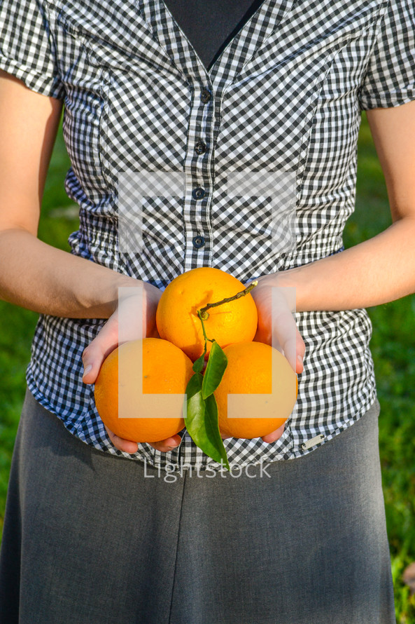 girl holding oranges 