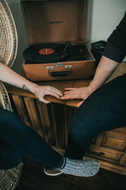 a couple sitting next to a record player 