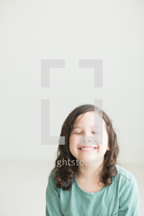 portrait of a smiling child with closed eyes 
