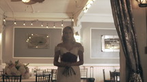 Model bride walking with roses indoors