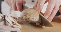 Close up of a chef knife slicing a portobello mushroom