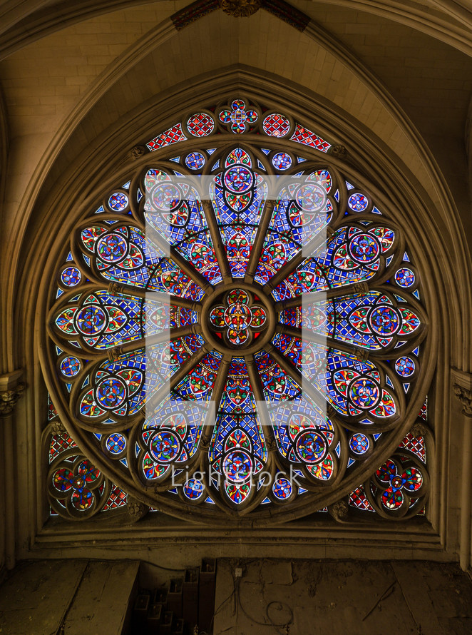 stained glass circular window, decorated with intricate designs resembling the petal arrangement of a rose. characteristic feature of Gothic architecture churches