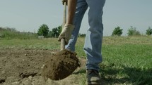 digging with a shovel to break ground 