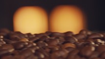 Roasted coffee beans on a conveyor belt with oven fire in the background
