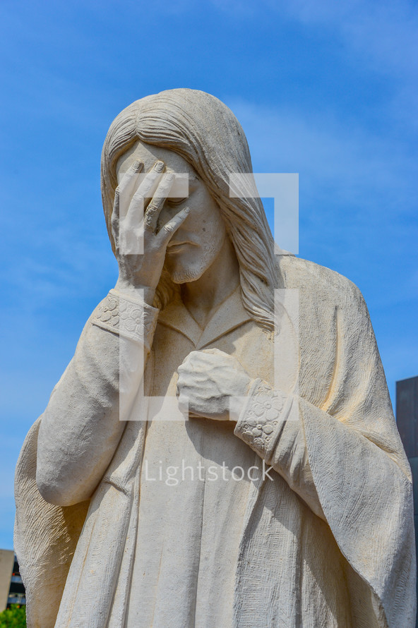 Statue of Jesus covering his face with his hands 
