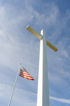 a tall white cross and an American flag