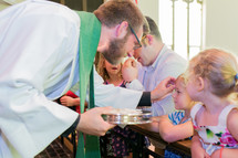 kneeling for communion and a child receiving a blessing 