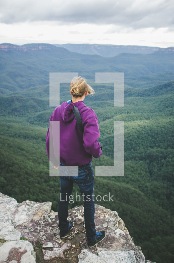 woman standing on a ledge looking out enjoying the view 
