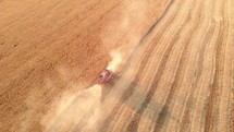 Aerial view of combine harvester harvesting wheat. Combine harvester working on the large wheat field. Harvester is working during harvest time, machine is cutting grain plants. Agriculture concept.