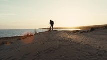 Videomaker On A Sand Dune At Sunset