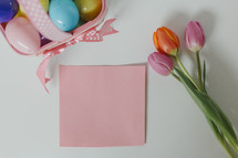plastic Easter eggs, tulips, and blank paper 
