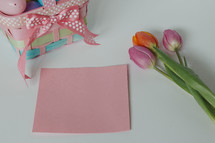plastic Easter eggs, tulips, and blank pink paper 