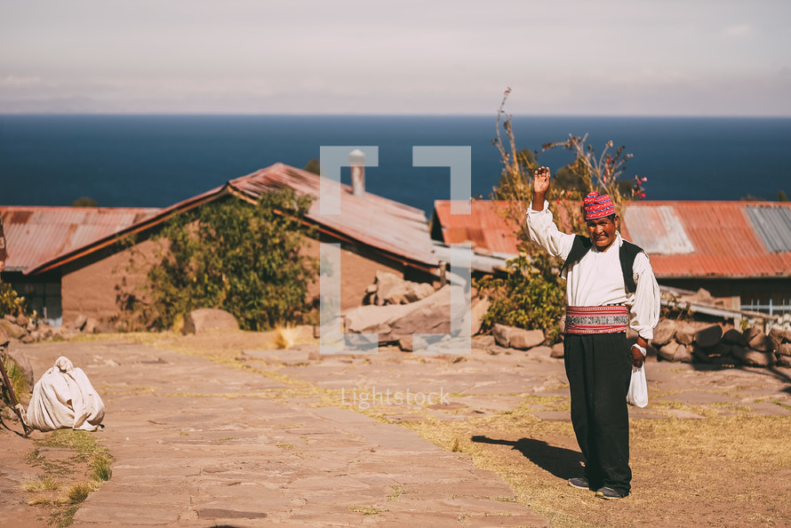 a man in Peru waving from a mountaintop 