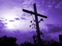 Vines on a cross in front of a purple sky showing that Jesus is the vine and we are the branches. It is the cross of Christ that symbolizes the hope and victory that there is salvation against sin and eternal life in Heaven through Jesus. 