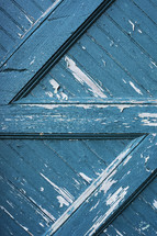 peeling blue paint on a barn door 