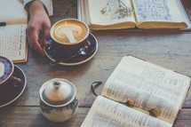 woman drinking a cappuccino and reading a Bible 