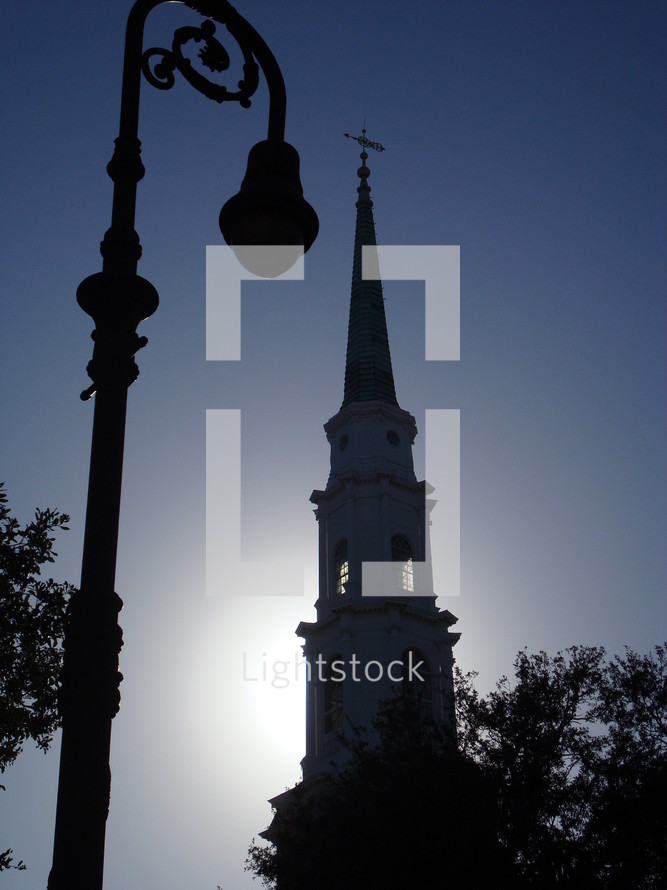 Silhouette of a light post and steeple 