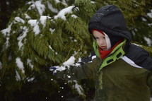boy child in a winter coat standing in snow 