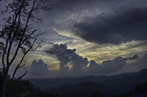 cloudy skies over mountain landscape at sunset 