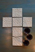 The Lord's Supper with bread in the shape of a cross and three little cups of wine. 