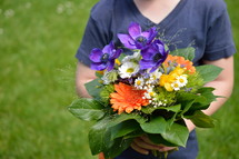 a child holding a bouquet of flowers 