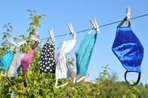 cloth face masks hanging on a clothesline drying 