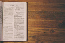 Open Bible on a wooden table.