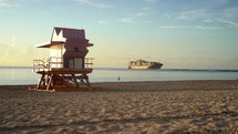 Early morning beach scene with cargo ship entering canal