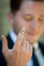 wedding bands held by a finger