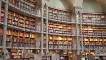 Paris, France - March 19, 2024: The Salle Ovale at the Bibliothèque Nationale de France, Richelieu an elegant oval room wood-paneled walls and beautiful ceiling, adorned with valuable book collection