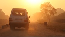 van driving on a dirt road at sunset 