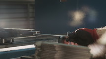 Close up of a Production line worker bending metal parts with a machine