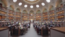 Paris, France - March 19, 2024: The Salle Ovale at the Bibliothèque Nationale de France, Richelieu an elegant oval room wood-paneled walls and beautiful ceiling, adorned with valuable book collection