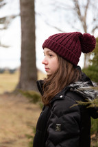a teen girl standing outdoors in winter 