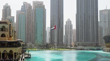 United Arab Emirates flag waving under the skyscrapers.