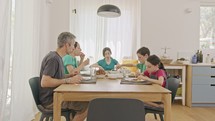 Family eating pancakes and fruits for breakfast