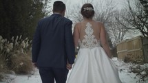 bride and groom walking hand in hand outdoors 