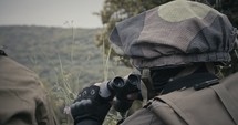 Israeli soldiers in a surveillance and reconnaissance mission using binoculars