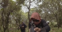 POV footage of armed terrorists patrolling a forest area