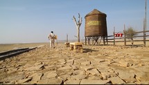 water tower near train tracks in a desert 