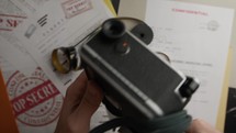 Opening a Vintage camera on Top Secret Documents On Table