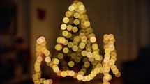 Santa Claus Putting on glasses with blurred Christmas tree 